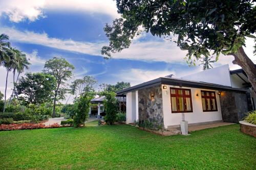 a house with a green lawn in front of it at Anodawa Boutique Villa in Tangalle