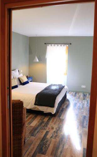 a bedroom with a bed and a window at Le Jardin des Chouchoux in Brantôme