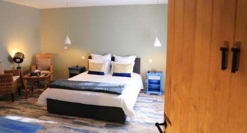 a bedroom with a bed with blue and white pillows at Le Jardin des Chouchoux in Brantôme