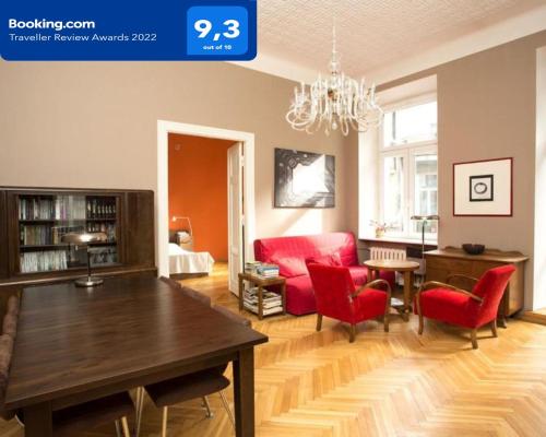 - un salon avec une table en bois et des chaises rouges dans l'établissement Star Apartment City Center, à Łódź
