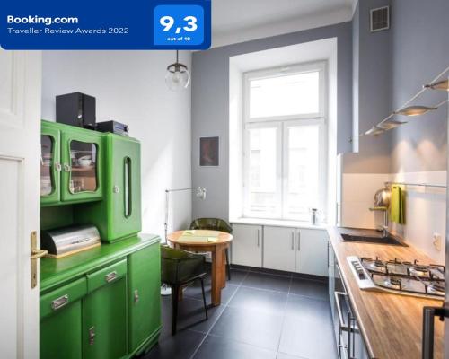 a kitchen with green cabinets and a table at Star Apartment City Center in Łódź