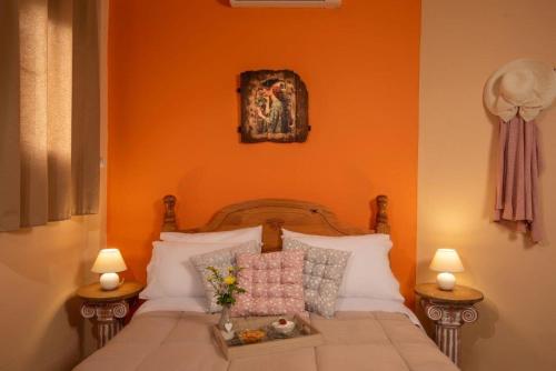 a bedroom with a bed with an orange wall at Villa Georgia in Kalyves