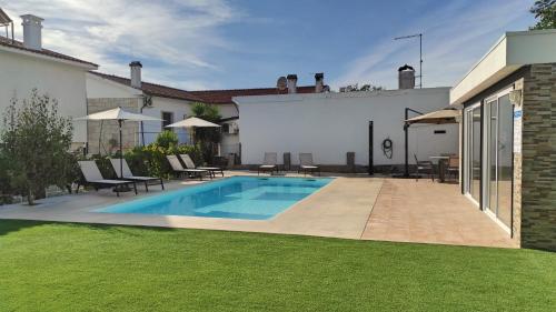 a swimming pool in the backyard of a house at Villa D'Uvale Douro in Alijó