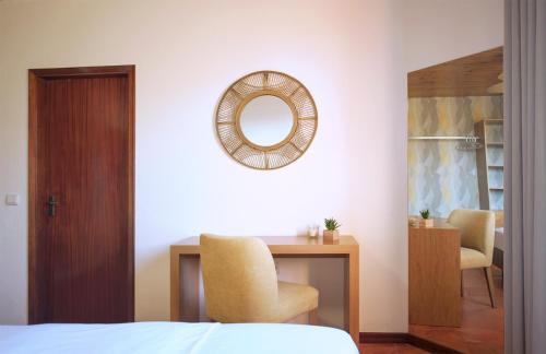 a bedroom with a desk and a mirror on the wall at Theresia's in Porto Santo