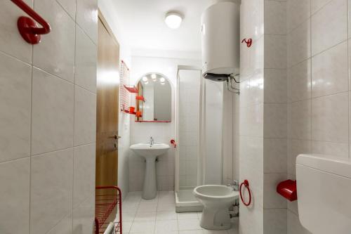 een witte badkamer met een toilet en een wastafel bij El Tobià in Campitello