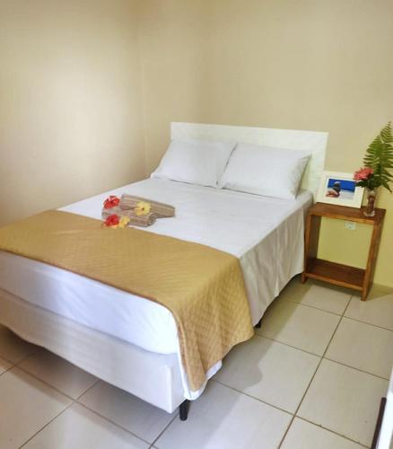 a bedroom with a bed and a night stand at Pousada Carpediem in Morro de São Paulo