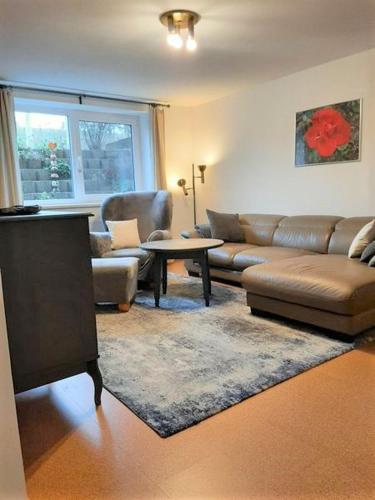 a living room with a couch and a table at "Libelle am Bernsteinsee" Zimmer in Stüde, Sassenburg in Sassenburg