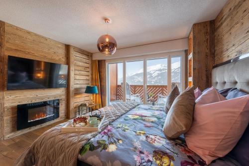 - une chambre avec un lit, une cheminée et une télévision dans l'établissement Apartment 42 Crans, à Crans-Montana