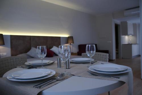 una mesa con platos y copas de vino. en Aparthotel K, en Figueres