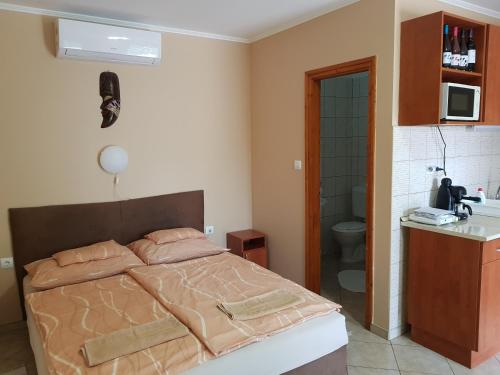 ボガーチにあるMuskátli Apartmanのベッドルーム1室(ベッド1台付)、バスルーム(シンク付)