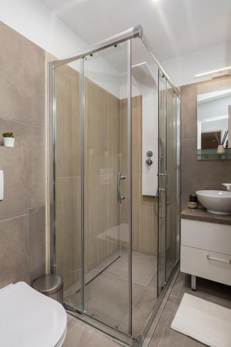 a glass shower in a bathroom with a sink at Main Street Apartments 2 in Rijeka