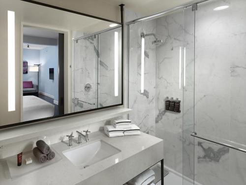 a bathroom with a sink and a shower with a mirror at Axiom Hotel in San Francisco