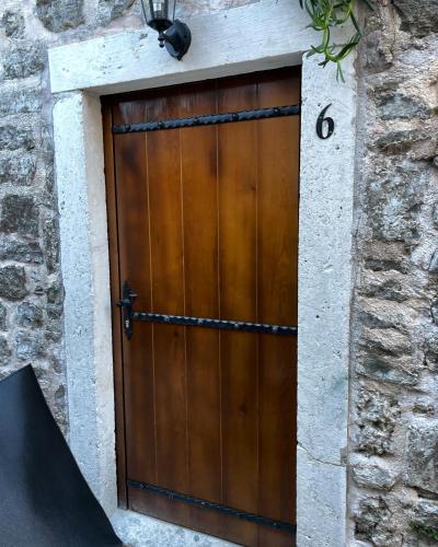 a wooden door in a stone building with a ramp at Old town house with private garden in Budva
