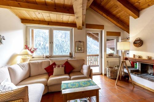 ein Wohnzimmer mit einem Sofa und einem Kamin in der Unterkunft Trevisan in Campitello di Fassa
