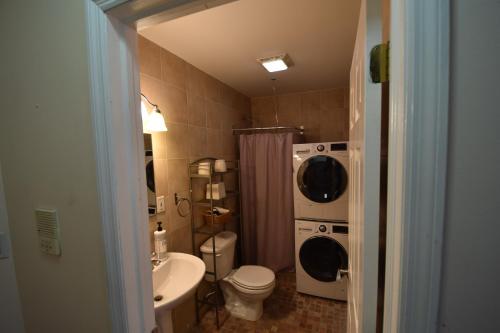 a bathroom with a toilet sink and a washing machine at Riverhouse Extended Stay Apartment in Jersey City