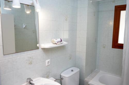 un bagno con un water, un lavandino e uno specchio di Apartamentos Vistalmar Mallorca a Cala Figuera