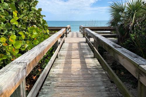 a wooden boardwalk leading to the ocean on a beach at Satellite Beach Townhome with Patios 2 Mi to Beach in Satellite Beach