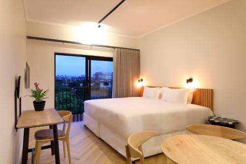 a bedroom with a large white bed and a table at Hyatt House Johannesburg Rosebank in Johannesburg