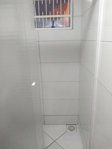 a white shower with a window in a bathroom at Residencial Melodia in Campos Novos