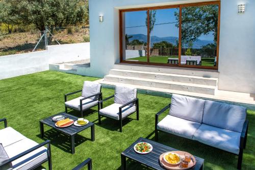 patio z krzesłami i stołami na trawie w obiekcie Alpujarra Arena w mieście Soportújar