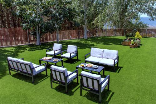 a group of chairs and tables on a lawn at Alpujarra Arena in Soportújar