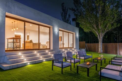 a patio with chairs and tables on a lawn with lights at Alpujarra Arena in Soportújar