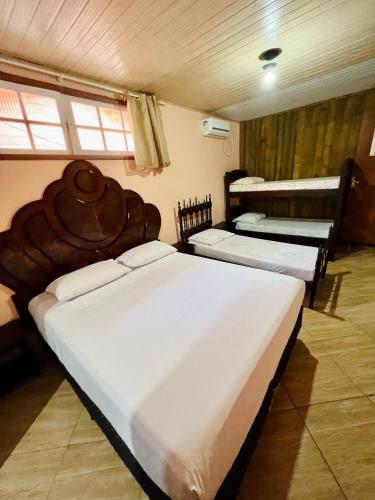 a bedroom with two beds and two bunk beds at Pousada Rosa Center in Praia do Rosa