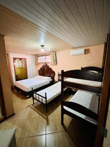 a room with two beds and a couch in it at Pousada Rosa Center in Praia do Rosa