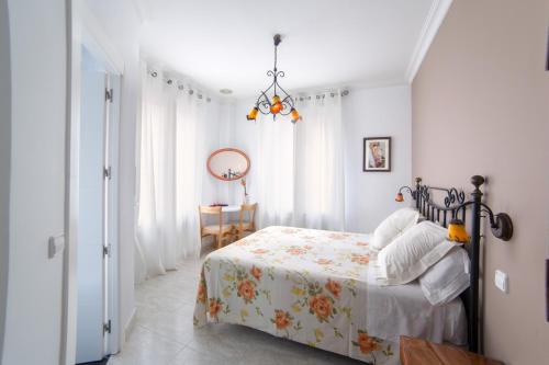 Dormitorio blanco con cama y mesa en Hostal Barrera, en Madrid