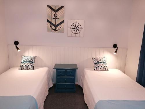 a room with two beds and a table between them at Apartamento Mar Azul-Ocean View in Lagos