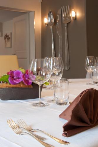 une table avec des verres à vin et des fleurs dessus dans l'établissement L'Etape 9, à Klingenthal