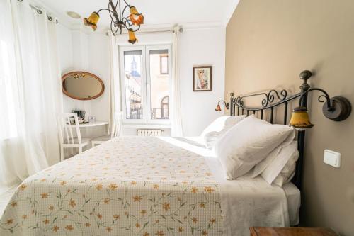 Habitación blanca con cama y ventana en Hostal Barrera, en Madrid