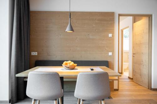 a dining room table with chairs and a bowl of fruit on it at Villa David Dolomites in Selva di Val Gardena