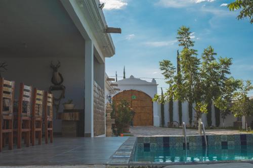 a house with a swimming pool in front of a building at Hotel Posada las Nubes in Parras de la Fuente
