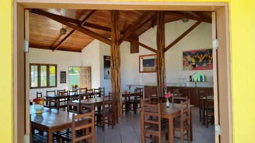una sala da pranzo con tavoli e sedie in legno di Pousada Costa do Sol a Canavieiras