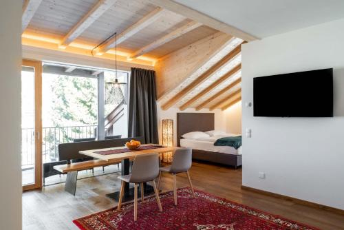 a living room with a dining room table and a bedroom at Villa David Dolomites in Selva di Val Gardena