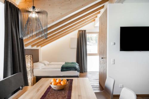 a room with a bed and a table with a bowl of oranges at Villa David Dolomites in Selva di Val Gardena