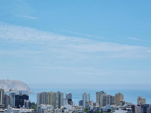 a view of a city with buildings and mountains at Skyliving Towers Apartments - Perú in Lima