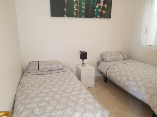 um quarto com duas camas e uma foto na parede em Sunlight Apartment - Molino Blanco - La Zenia em Playas de Orihuela