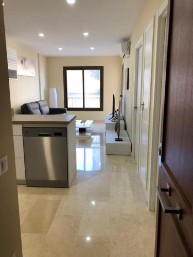 a kitchen with a counter and a living room at Moderno Apartamento en Primera línea Paseo Marítimo Fuengirola in Fuengirola