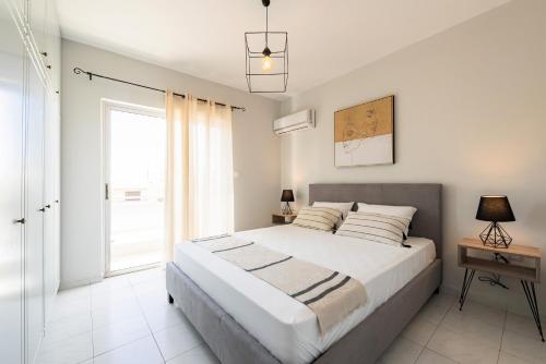 a white bedroom with a large bed and a window at City Center Elite Suite in Rhodes Town