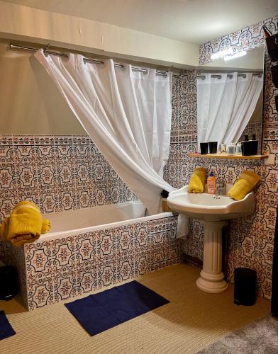 une salle de bain avec un lavabo et une baignoire et un lavabo dans l'établissement Le sauvage, à La Tremblade