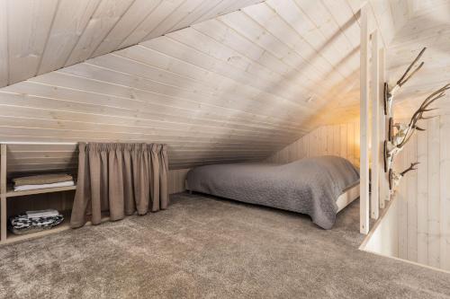 sypialnia z łóżkiem na poddaszu w obiekcie Riese Apartments w mieście Riešė
