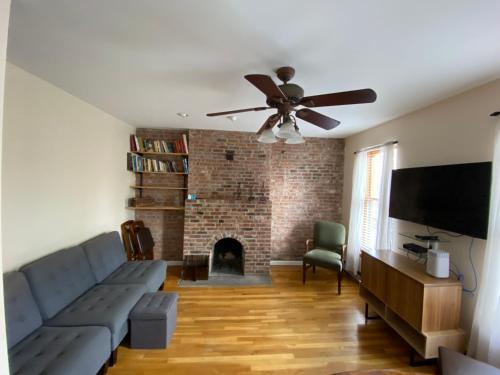 a living room with a couch and a ceiling fan at Riverhouse Extended Stay Apartment in Jersey City