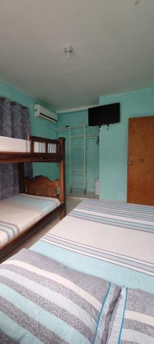 a bedroom with two bunk beds and a flat screen tv at Casa Hostel San Andres in San Andrés