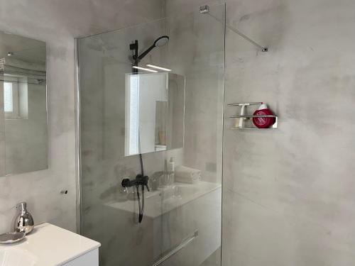 bagno con doccia in vetro e lavandino di Luxury studio, sea view, pool a La Asomada
