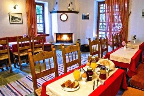 une salle à manger avec deux tables et une cheminée dans l'établissement Heliodora, à Kissos