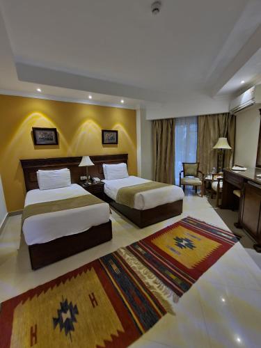 a hotel room with two beds and a piano at The Guard Hotel in Cairo