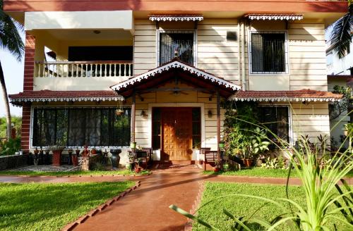 uma casa com uma porta da frente e um alpendre em SHANU'S SEASIDE INN - A Guesthouse, 100 metres to Candolim Beach em Candolim