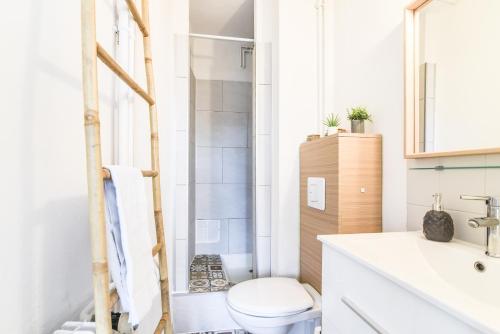 uma casa de banho com um WC branco e um lavatório. em Le Petit Vauban em Estrasburgo